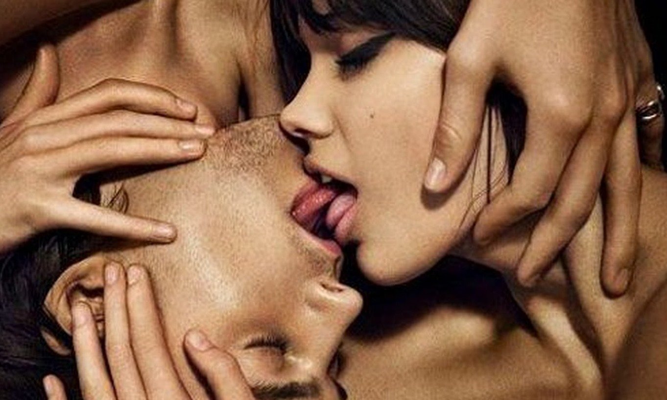 муж и жена целуются в губы в кровати